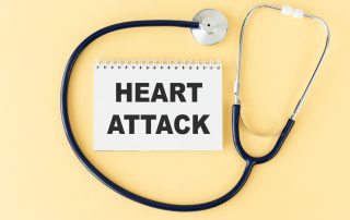 Stethoscope with "Heart Attack" written on notepad, representing health awareness and cardiac emergencies.
