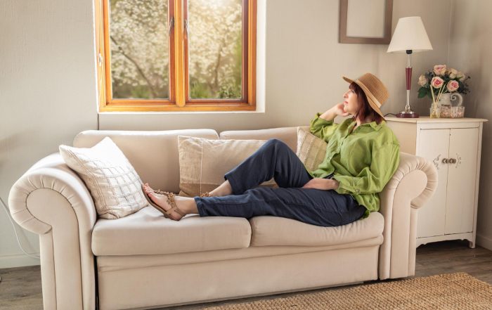 Lorie Eber, Nutritionist and Board-Certified Health Coach, smiling and seated on a stool in a professional photo for her wellness coaching practice in Irvine, California